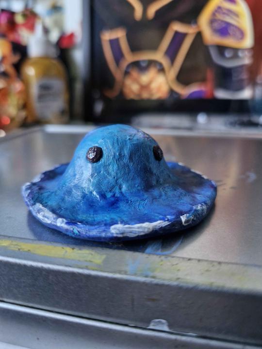 A sculpted clay figure of a puddle slime, painted with shades of blue.